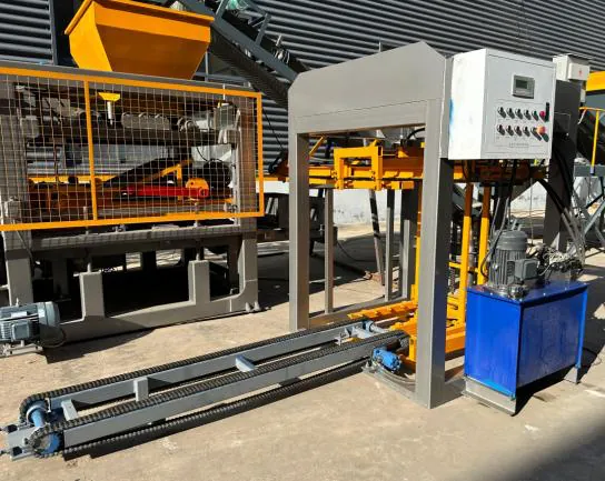 Pallet feeder with its own control box and blue hydraulic unit, in front of the QT5-15 main machine.