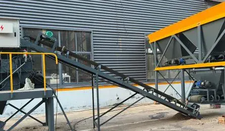 Inclined belt conveyor running from the batching station up towards the mixer platform.